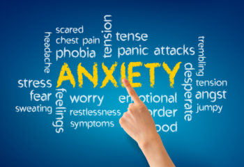 Hand pointing at a Anxiety word illustration on blue background.