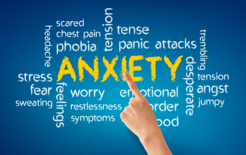 Hand pointing at a Anxiety word illustration on blue background.