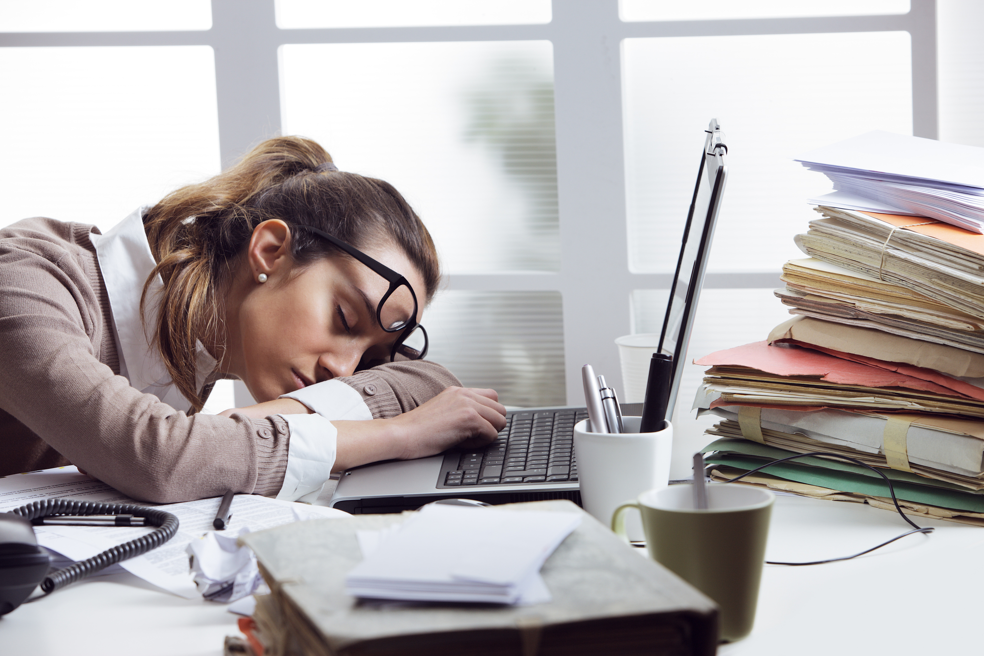 Fatigue woman at office desk - 9 Symptoms Of Candida Overgrowth