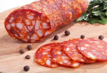 Chorizo ​​sausage pepperoni with herbs and pepper on the board