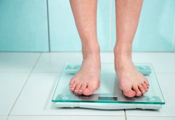 close up of woman standing on a scale in bathroom